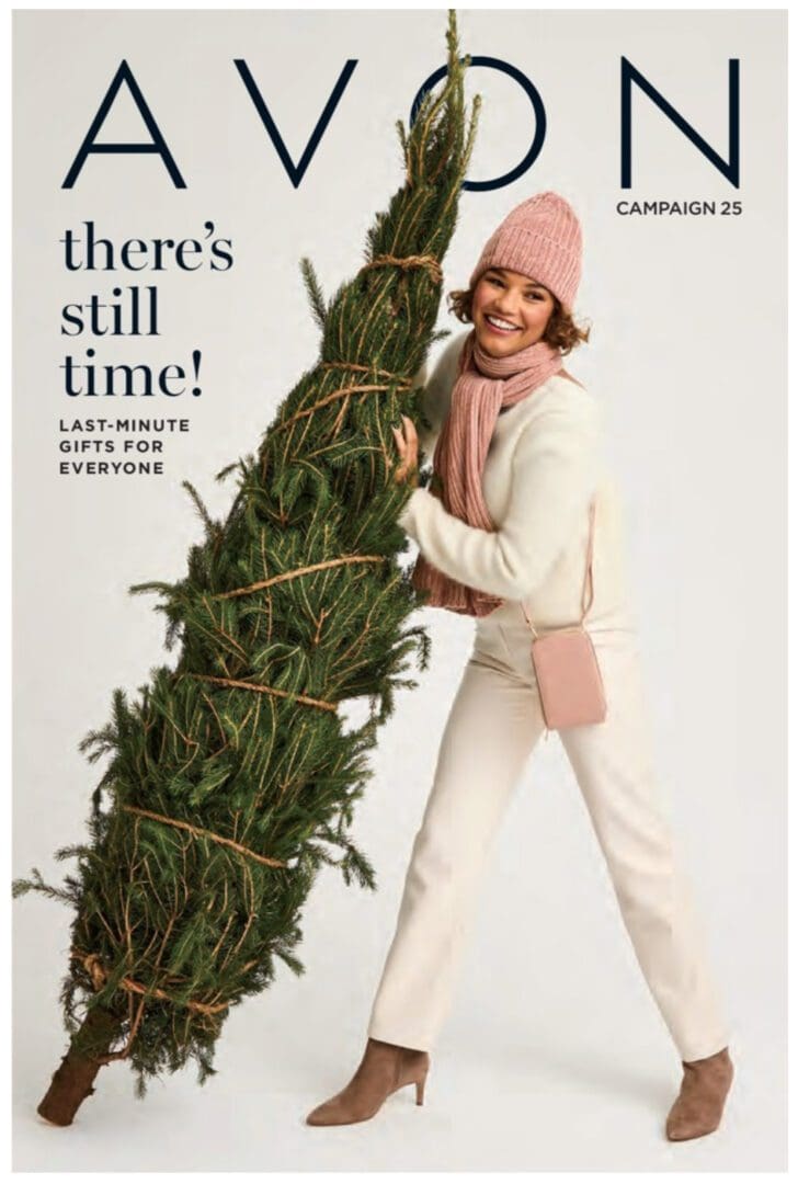 A woman holding a christmas tree in front of her face.