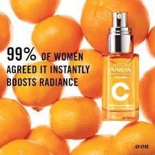 A bottle of avon vitamin c serum is surrounded by oranges.