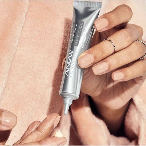A person holding onto an empty tube of cream